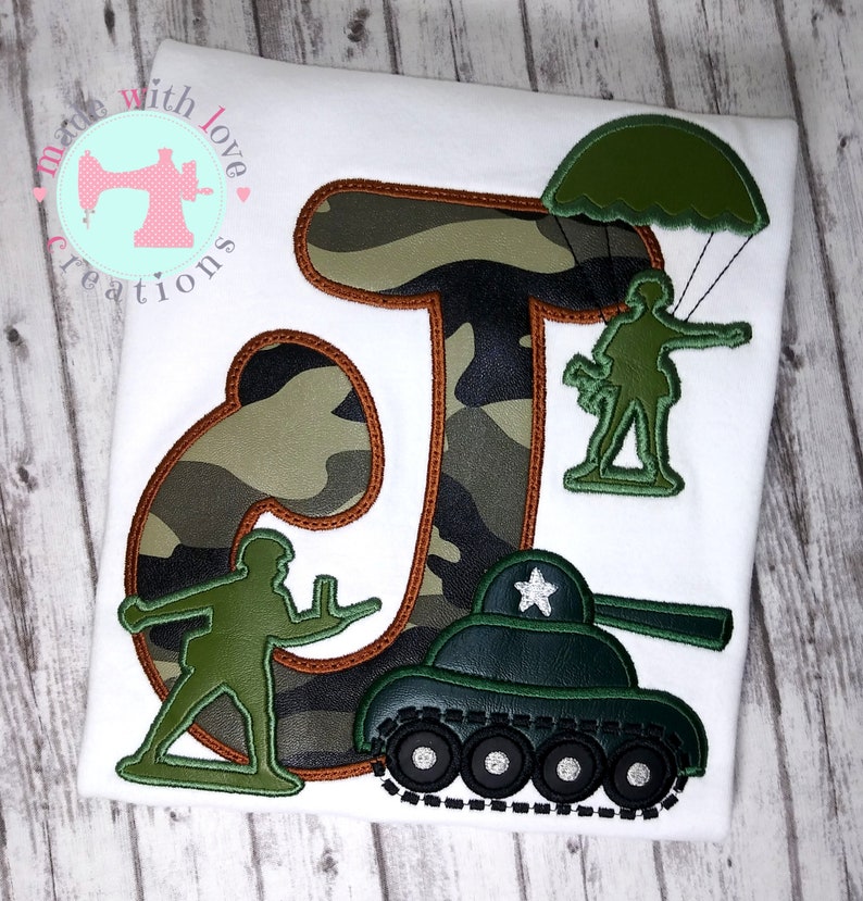 May include: Camouflage letter J with a green toy soldier, a green toy tank, and a green toy soldier parachuting. The letter J is outlined in orange.