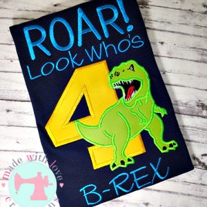 May include: A blue t-shirt with a yellow number four and a green dinosaur with the text "Roar! Look Who's B-Rex" in blue and green.