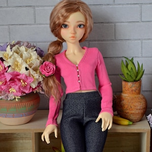 May include: A white ceramic mug with a black handle and the text "But First, Coffee" in a bold, black font. The mug is set against a blurred background, suggesting a cozy setting.