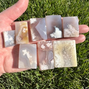 May include: Eight polished agate slices with white and gray patterns. The slices are rectangular and have a smooth, polished surface.