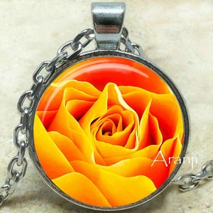 May include: A silver chain necklace with a round pendant featuring a close-up image of a bright orange rose.