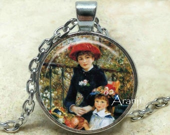 May include: A silver chain necklace with a round glass pendant featuring a painting of two women in a garden setting. The woman in the foreground is wearing a red hat and a black dress. The woman in the background is wearing a blue dress and a white hat. The pendant is surrounded by a silver frame.