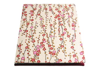May include: A square box with a cream-colored lid featuring a floral pattern of red and pink blossoms on gray branches. The box has a dark burgundy base, and the design is reminiscent of Japanese art.