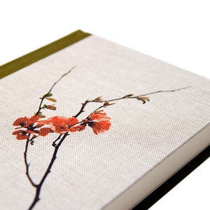 May include: A hardcover book with a linen cover featuring a floral design. The cover displays a branch with red flowers and buds. The spine is olive green, and the pages are white.