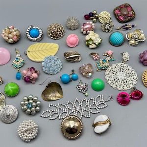 May include: A collection of colourful and unique earrings, including floral, geometric, and abstract designs. The earrings are made from a variety of materials, including metal, glass, and plastic.