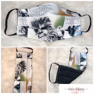 Puede incluir: Una mascarilla facial en blanco y negro con tem&aacute;tica de Star Wars. La mascarilla presenta un collage de im&aacute;genes que incluyen a Chewbacca, un Stormtrooper y las palabras "Star Wars". La mascarilla est&aacute; hecha de tela y tiene una banda el&aacute;stica negra.