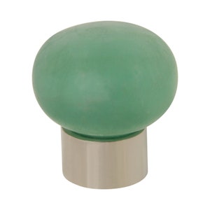 Op de afbeelding: Een groene keramische knop met een zilveren basis. De knop is rond en heeft een gladde afwerking.