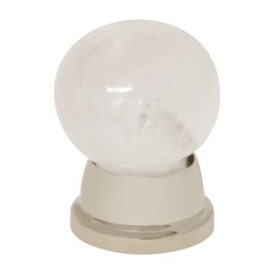 May include: White crystal ball knob with a silver base. The knob is round and has a smooth, polished surface. The base is made of metal and has a shiny finish.