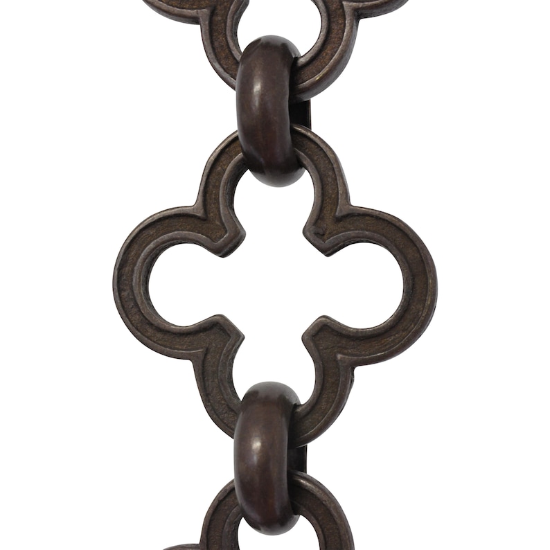May include: Close-up of a decorative chain with a repeating quatrefoil design. The chain links are a dark bronze color, with a matte finish. The links are connected by oval-shaped connectors.