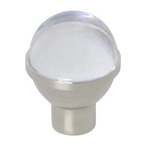 Op de afbeelding: Een zilveren kastknop met een transparante glazen koepel en een witte binnenkant. De knop heeft een ronde basis en een cilindrische steel.