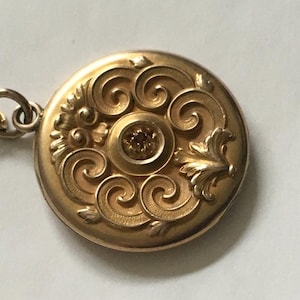 Antique gold filled locket art nouveau embossed front with small garnet 24 inch antique gold filled watch chain .