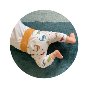 Calças de bebé Dinossauros | Leggings de algodão orgânico para bebé e criança | Calças saruel em malha para bebé com Dinossauros e folhas