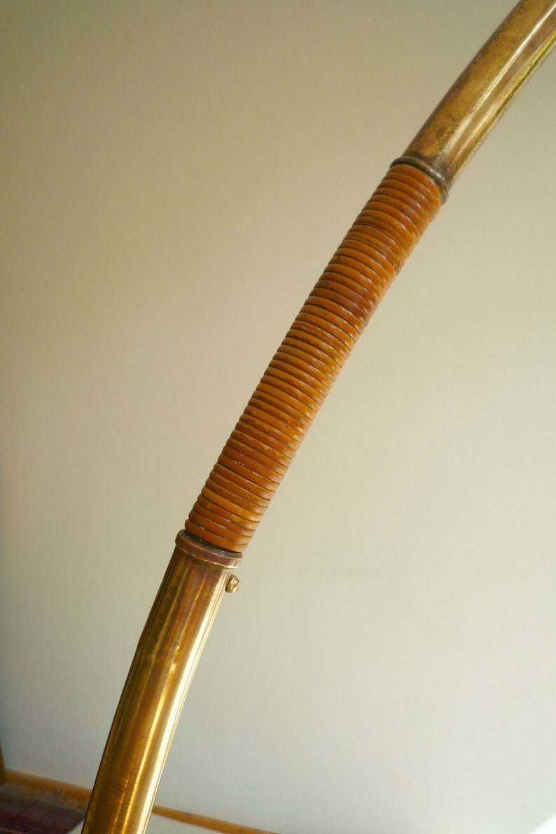 May include: A gold-colored metal lamp base with a brown woven rattan covering.