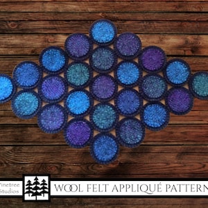 May include: Wool felt appliqué pattern for a blue and purple circle design. The pattern is called "Wool Felt Appliqué Pattern".
