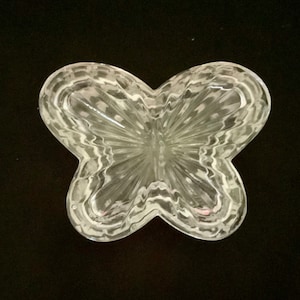 May include: A clear glass butterfly-shaped trinket box with a textured design.