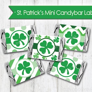 Puede incluir: Cuatro etiquetas imprimibles para mini barritas de chocolate con un diseño de trébol en verde y blanco. Las etiquetas tienen diferentes patrones, incluyendo lunares, rayas y chevron. El texto "St. Patrick's Mini Candybar Labels" está en la parte superior de la imagen.