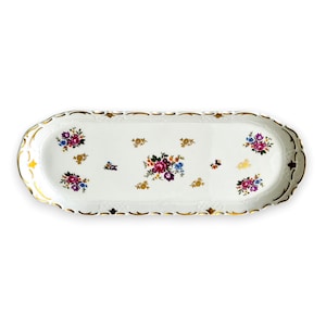 May include: An oval white porcelain serving tray featuring a scalloped edge with gold trim. The center and sides are decorated with small, colorful floral bouquets in shades of pink, purple, blue, and yellow, accented by small gold leaf motifs.