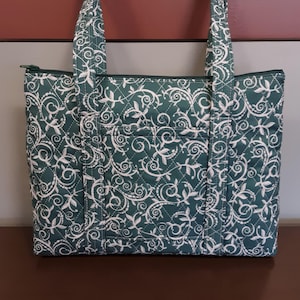 Monedero acolchado verde con remolinos blancos