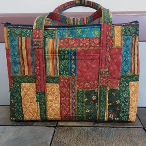 Monedero acolchado con estampado de patchwork colorido en rojo, verde, azul y dorado