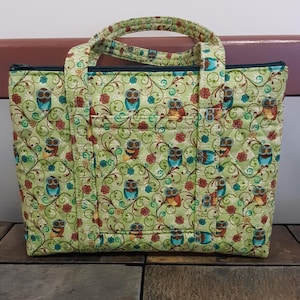 Bolso de mano acolchado con estampado de flores en tonos verde, azul, dorado y tostado de búhos