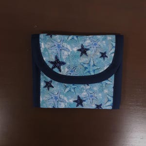 Cartera acolchada de tres pliegues con estampado de estrellas azules y estrellas de la marina