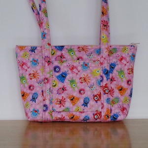Monedero acolchado pequeño con lindos monstruos y extraterrestres en color rosa para niñas