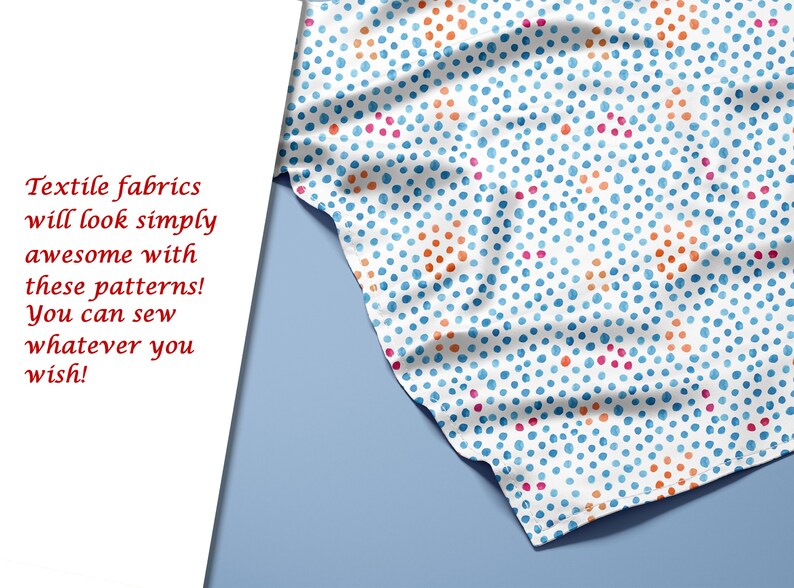 May include: A white fabric with a repeating pattern of blue, orange, and pink polka dots. The fabric is folded and draped over a blue surface.