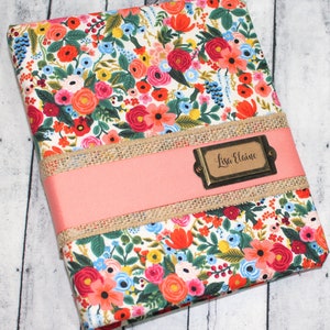 May include: A floral patterned hardcover journal with a pink ribbon and a gold metal tag that says "Lisa Elaine".
