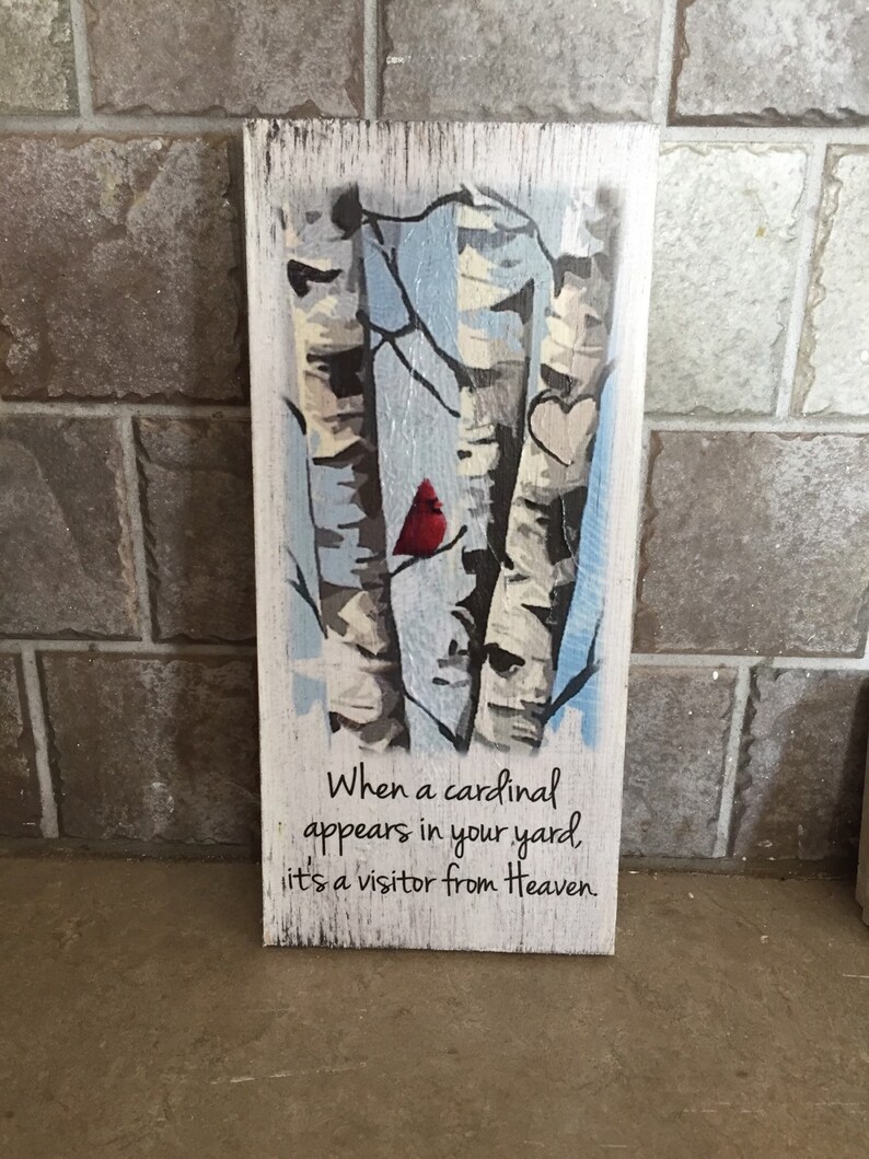 Puede incluir: Un letrero de madera con una imagen pintada de tres abedules, un cardenal rojo y dos corazones. El letrero tiene el texto "Cuando un cardenal aparece en tu jard&iacute;n, es un visitante del cielo."