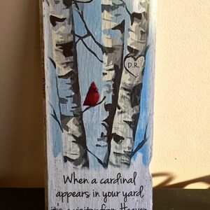 Puede incluir: Un letrero de madera con una imagen pintada de tres abedules y un cardenal rojo posado en una rama. El letrero tiene el texto "When a cardinal appears in your yard, it's a visitor from Heaven." y un coraz&oacute;n con las iniciales "D.R." pintadas en &eacute;l.