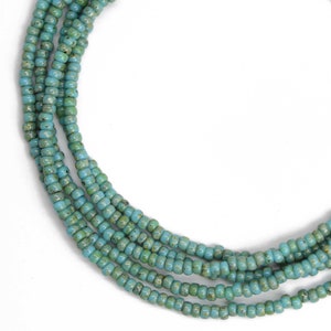 May include: A turquoise blue beaded necklace with multiple strands of small beads.