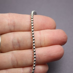 Peut inclure: Un collier en cha&icirc;ne argent&eacute;e avec de petites perles rondes.