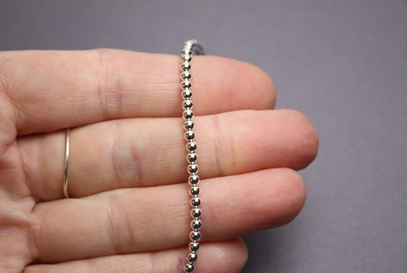 Peut inclure: Un collier en cha&icirc;ne argent&eacute;e avec de petites perles rondes.