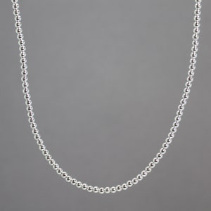 Peut inclure: Un collier de perles argent&eacute;es avec un design simple. Le collier est compos&eacute; de petites perles rondes uniform&eacute;ment espac&eacute;es.