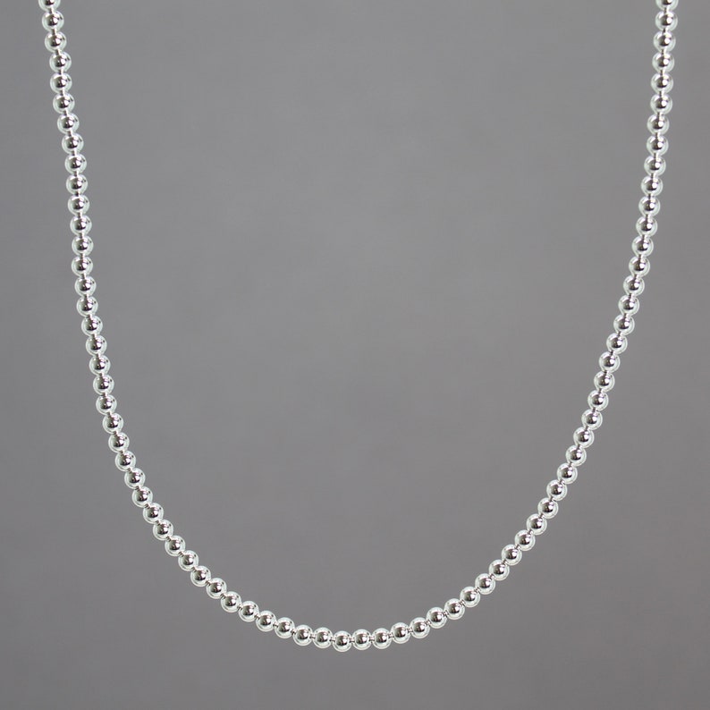 Peut inclure: Un collier de perles argent&eacute;es avec un design simple. Le collier est compos&eacute; de petites perles rondes uniform&eacute;ment espac&eacute;es.