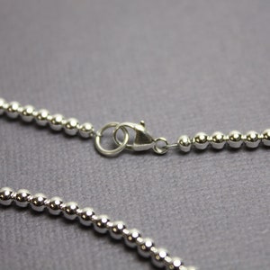 Peut inclure: Un collier de cha&icirc;ne en argent avec des perles et une fermeture &agrave; mousqueton.