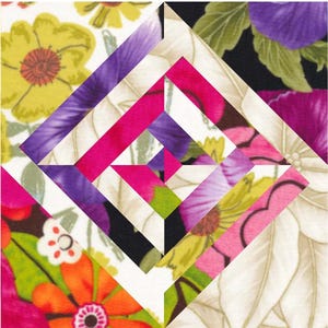 May include: A quilt block with a geometric design featuring white, pink, purple, and green floral fabric. The block is made up of squares and triangles, creating a diamond shape in the centre.