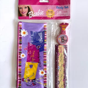 May include: A Barbie Study Set in a clear plastic package. The set includes a pencil pouch, ruler, and a charm. The pencil pouch is purple with a colorful design and the words "Funky hat", "hip Shoes", and "cute tee". The ruler is 12 inches long.
