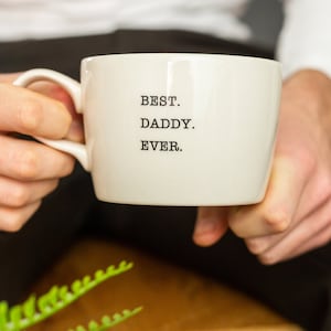 Puede incluir: Taza de cerámica blanca con texto negro que dice "BEST. DADDY. EVER."