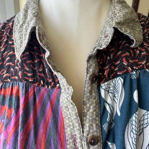 May include: A patchwork button-up shirt with a variety of colorful patterns, including floral, geometric, and abstract designs. The shirt has a collar and a button-up front.