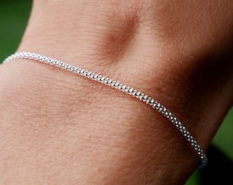 Pulseira feminina minimalista e espessa em prata de lei 925 reciclada, com corrente tipo pipoca ajustável e que permite empilhá-la.