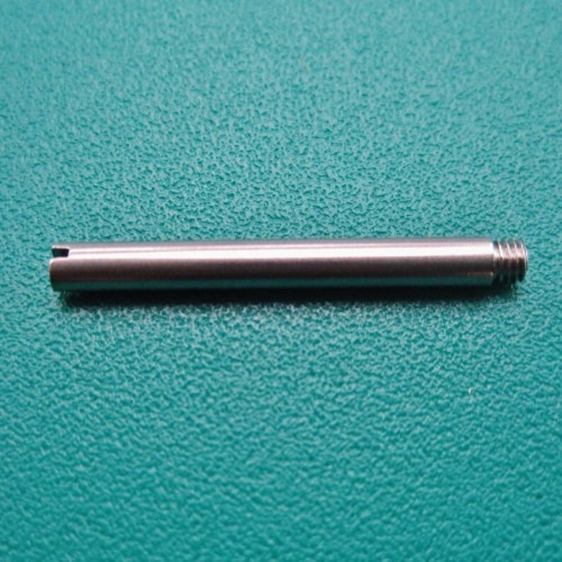 Puede incluir: Una varilla de metal plateado con un extremo redondeado y un extremo plano. La varilla mide aproximadamente 12,7 cm de largo.