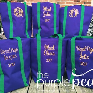Puede incluir: Seis bolsas de mano de color morado con correas verdes. Cada bolsa tiene un dise&ntilde;o bordado diferente, incluyendo nombres, monogramas y el texto "Royal Page" y "Maid". Las bolsas est&aacute;n dispuestas en una fila sobre una superficie de madera. El texto "the purple pea" es visible en la parte inferior de la imagen.
