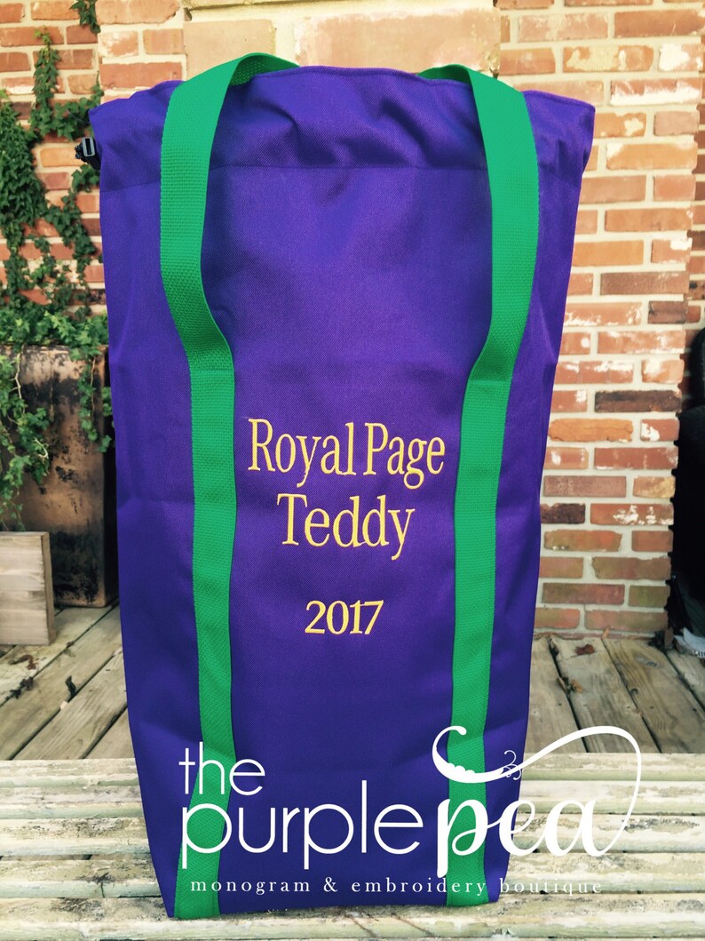 Puede incluir: Bolsa de tela morada con correas verdes y el texto "Royal Page Teddy 2017" bordado en dorado. La bolsa est&aacute; hecha por "the purple pea monogram & embroidery boutique".
