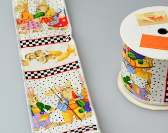 May include: A roll of white ribbon with a black and white checkered pattern and a repeating design of bunnies in colorful clothing. The ribbon is on a white surface.