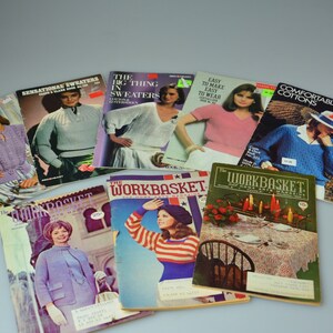 May include: A collection of vintage knitting pattern books and magazines. The books feature colorful covers with images of women wearing knitted sweaters and garments. The titles include "Cotton Up to Sweaters", "Sensational Sweaters", "The Big Thing in Sweaters", "Easy to Make Easy to Wear", "Comfortable Cottons", and "The Workbasket".