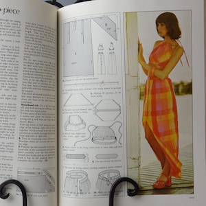 Pode incluir: Um padrão de costura vintage para um conjunto de duas peças, incluindo um top halter e uma saia com uma fenda alta. O padrão inclui instruções para fazer uma cintura e uma bainha para a parte superior. A modelo está usando uma versão completa do conjunto em tecido xadrez.