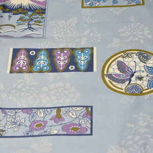 May include: A blue fabric with a repeating pattern of flowers, butterflies, and Japanese-inspired designs. The fabric features a mountain scene, stylized leaves, and a butterfly in a circle.