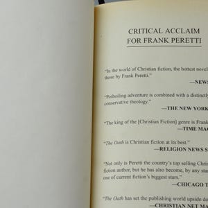 May include: Open book pages with text: "CRITICAL ACCLAIM FOR FRANK PERETTI." Quotes from Newsweek, The New York Times, Time Magazine, Religion News Service, Chicago Tribune, and Christian Net Magazine praising Frank Peretti's work.