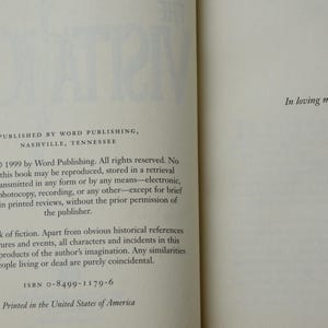 May include: Open book pages with text from a 1999 publication by Word Publishing, Nashville, Tennessee. The text includes copyright information, a statement about the work being fiction, and the ISBN. The right page has the text "In loving memory of Kip Fore."